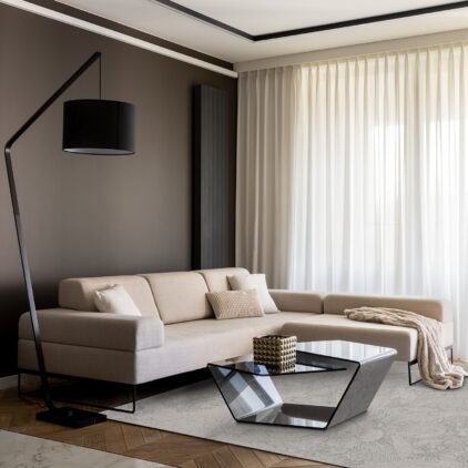 Fancy living room with stylish, beige, corner sofa, beige carpet, modern, black coffee table, simple black lamp and big windows behind curtains