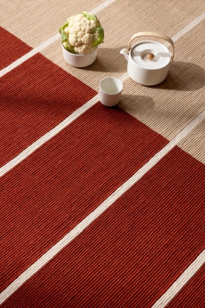 Beżowo Czerwony dywan w paski do salonu marki Marimekko.