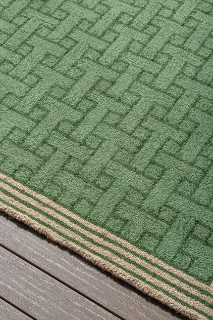 Zielony dywan zewnętrzny w geometryczny wzór marki Ted Baker